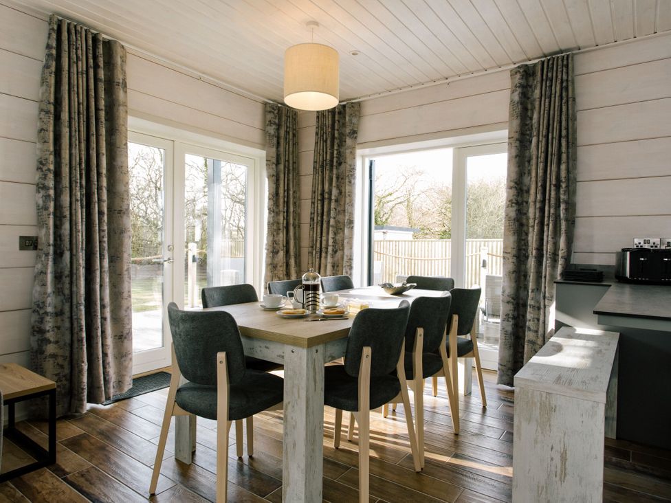A dining room with a table and chairs at The Glasshouse in Bude