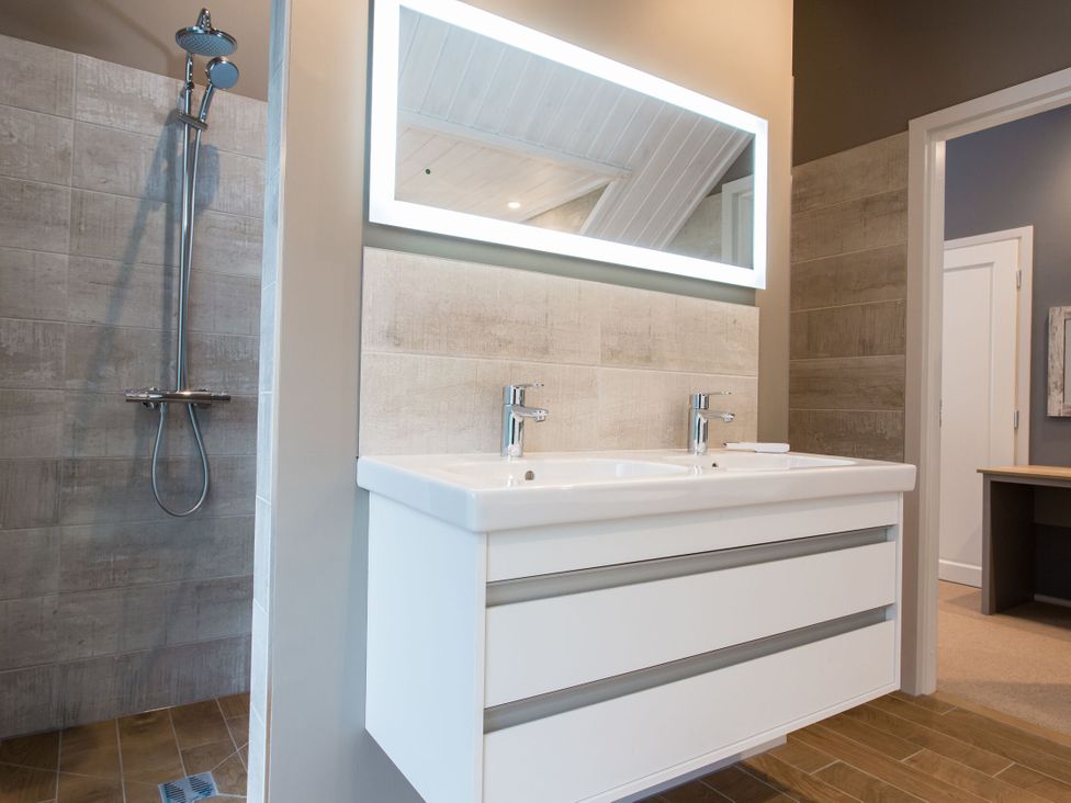 A bathroom with a double sink and shower at The Glasshouse in Bude