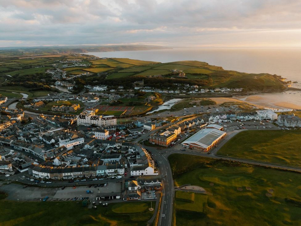 An aerial view of a coastal town with buildings and fields at Mullion Spa (Pet) in Bude