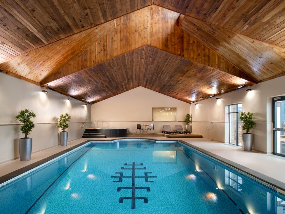 An indoor pool with wooden ceiling at Mullion Spa (Pet) in Bude