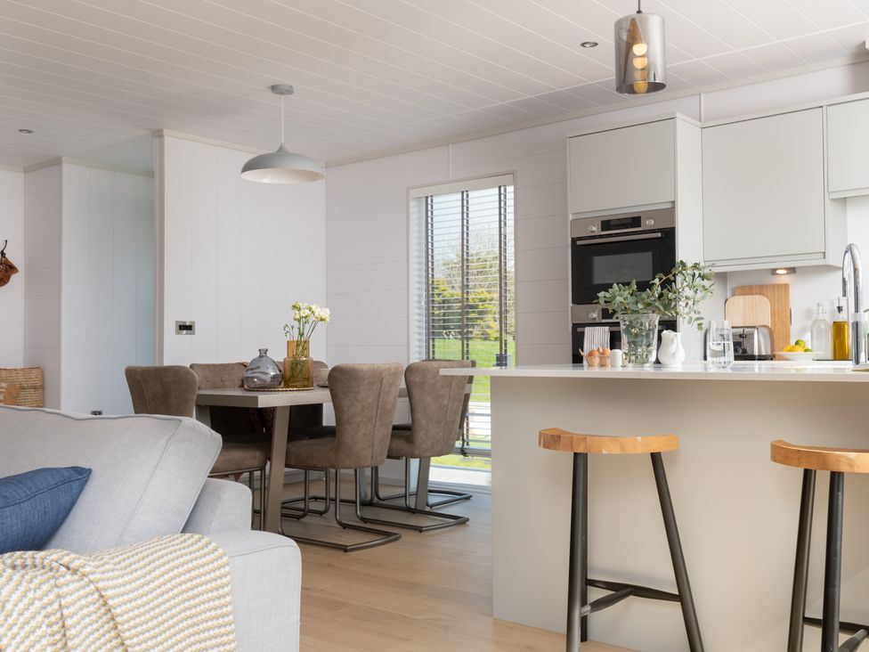 A kitchen with a dining area and appliances at Sennen 3 Spa Roof Terrace (Pet) Bude