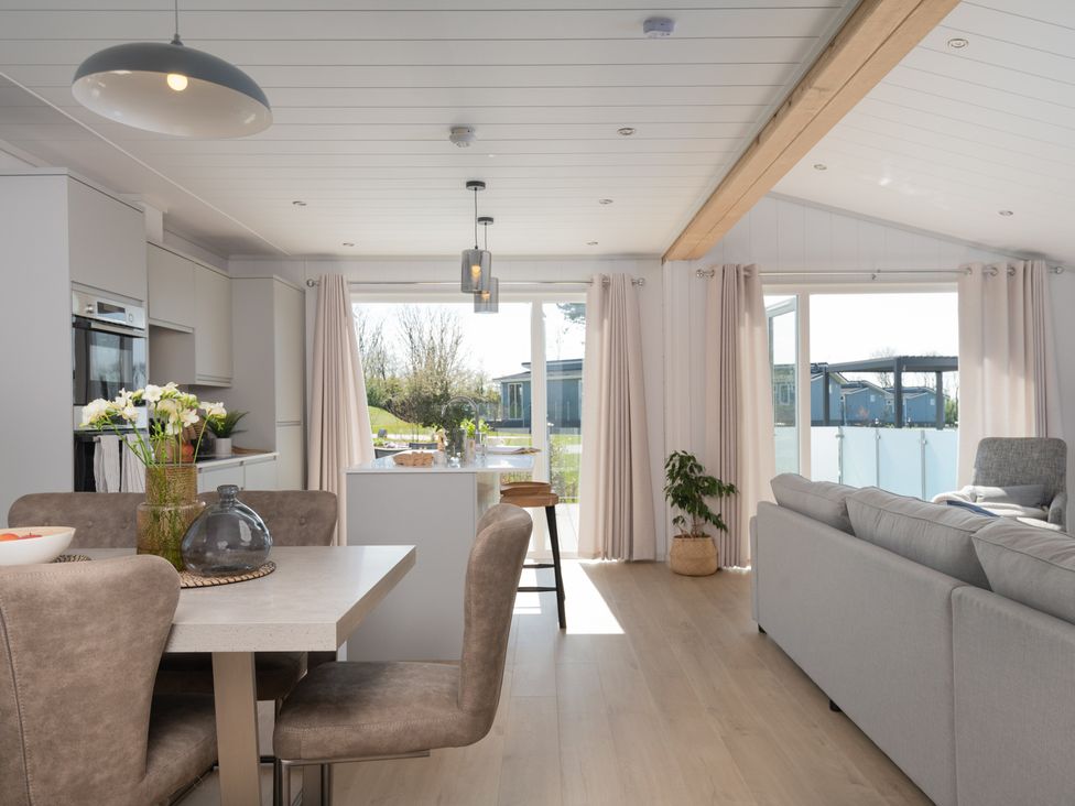 A living room with a dining area and kitchen at Sennen 3 Spa Roof Terrace Bude