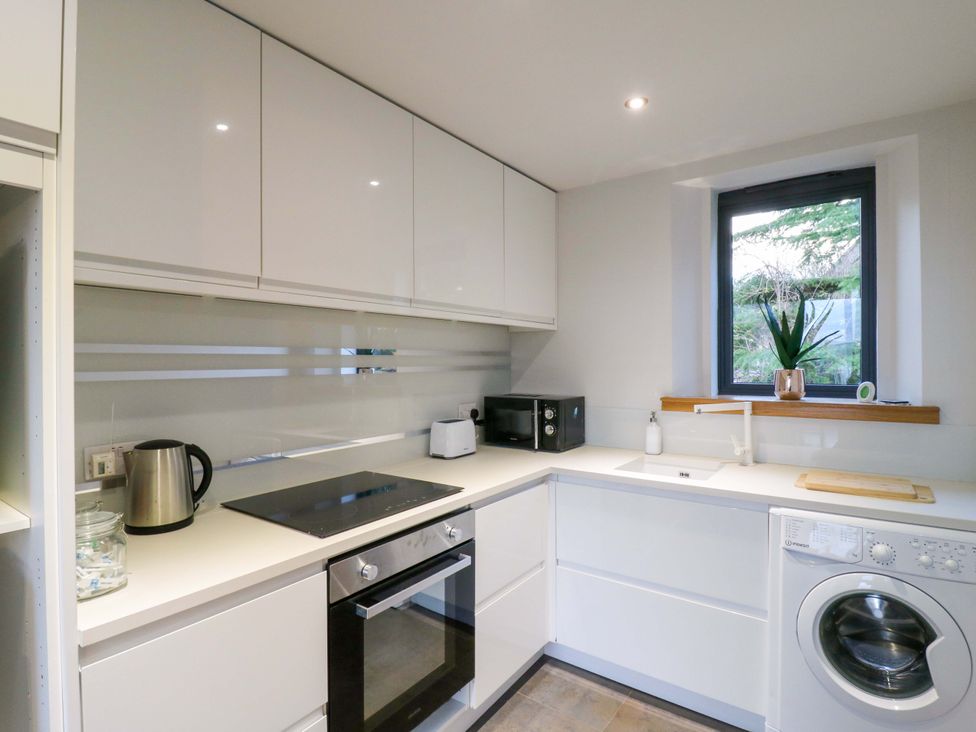 A kitchen with appliances and a window at The Lodge @ Lodge Farm Bedford