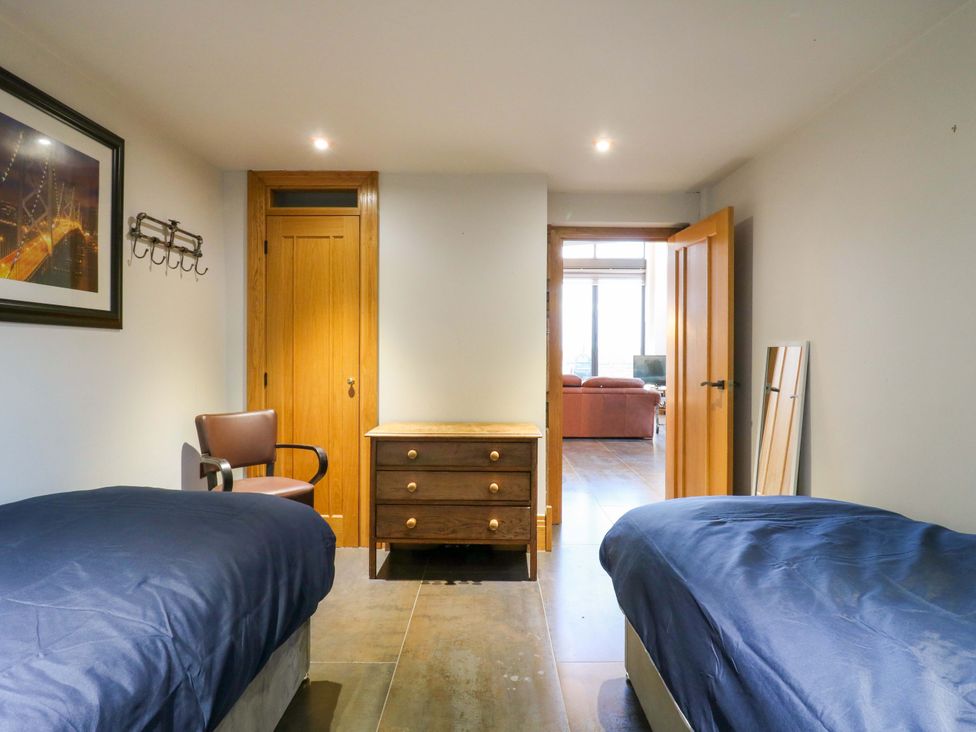 A bedroom with two beds and a dresser at The Lodge @ Lodge Farm Bedford
