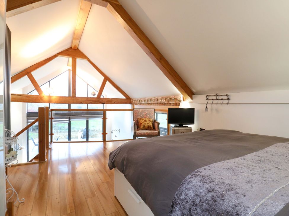 A bedroom with a bed and a television at The Lodge @ Lodge Farm Bedford