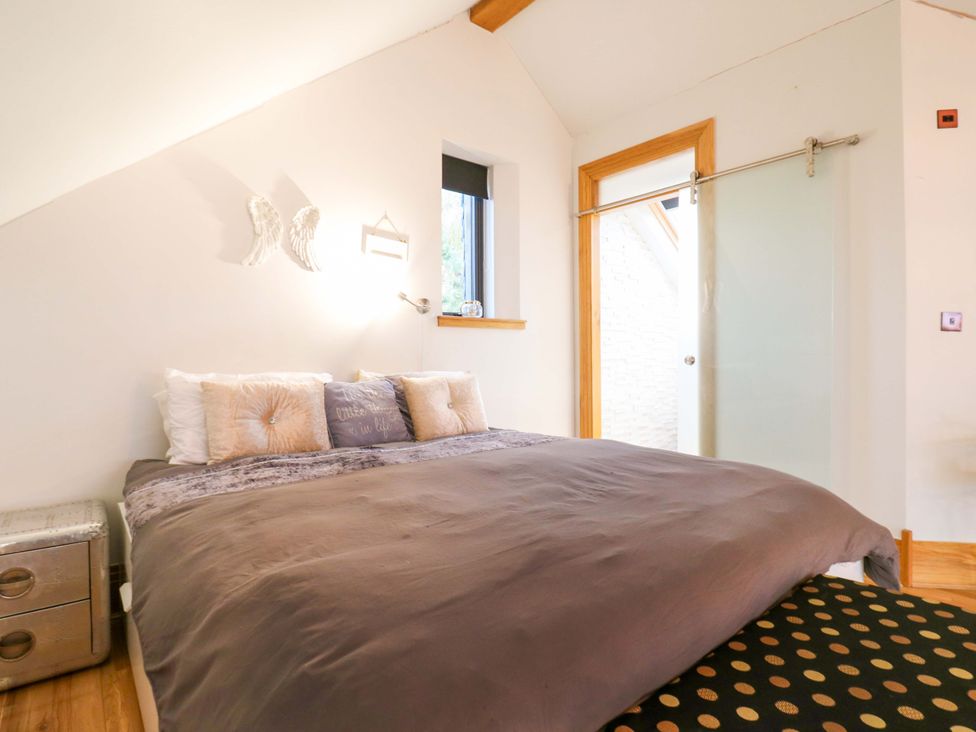 A bedroom with a bed and window at The Lodge @ Lodge Farm Bedford