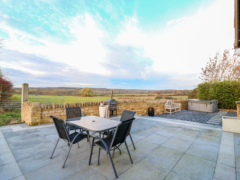 An outdoor area with seating and a hot tub at The Lodge @ Lodge Farm Bedford