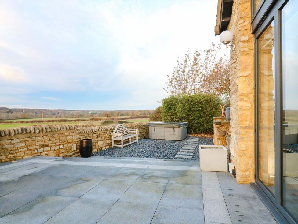 An outdoor area with a hot tub and bench at The Lodge @ Lodge Farm Bedford
