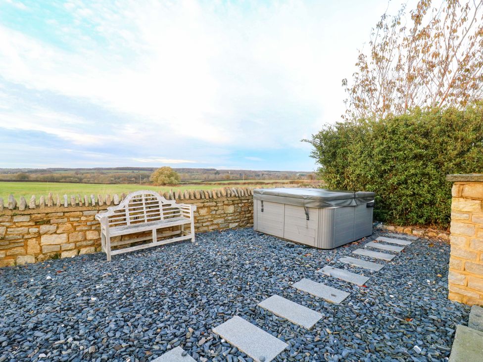 An outdoor area with a bench and a hot tub at The Lodge @ Lodge Farm Bedford