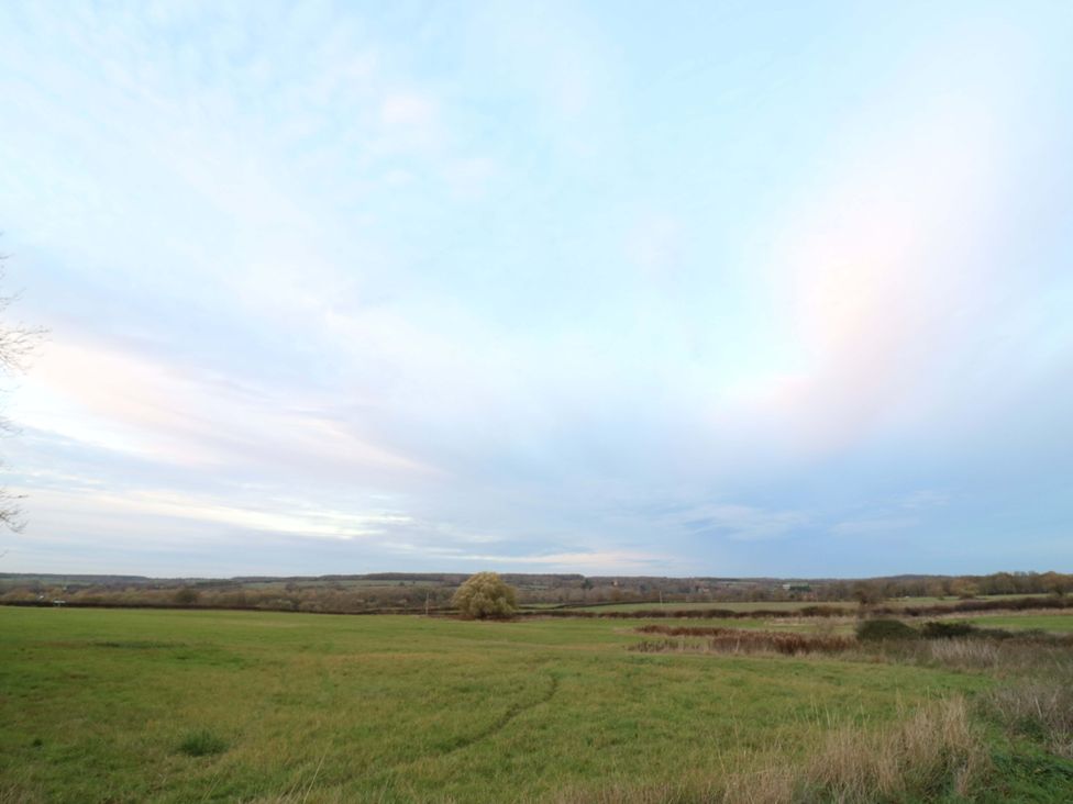 An open field with trees and a horizon at The Lodge @ Lodge Farm Bedford