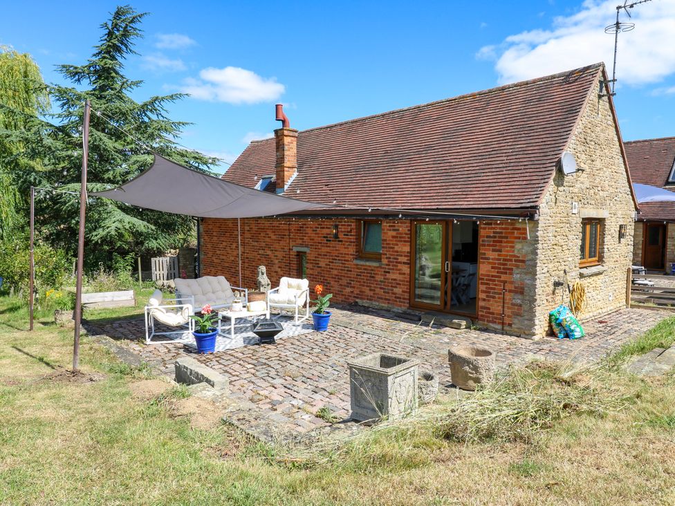 An outdoor seating area with a sofa and table at Barn Owl Cottage Carlton near Harrold
