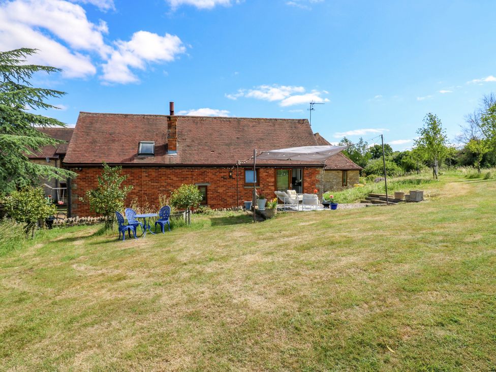 An outdoor area with a house and patio furniture at Barn Owl Cottage Carlton near Harrold