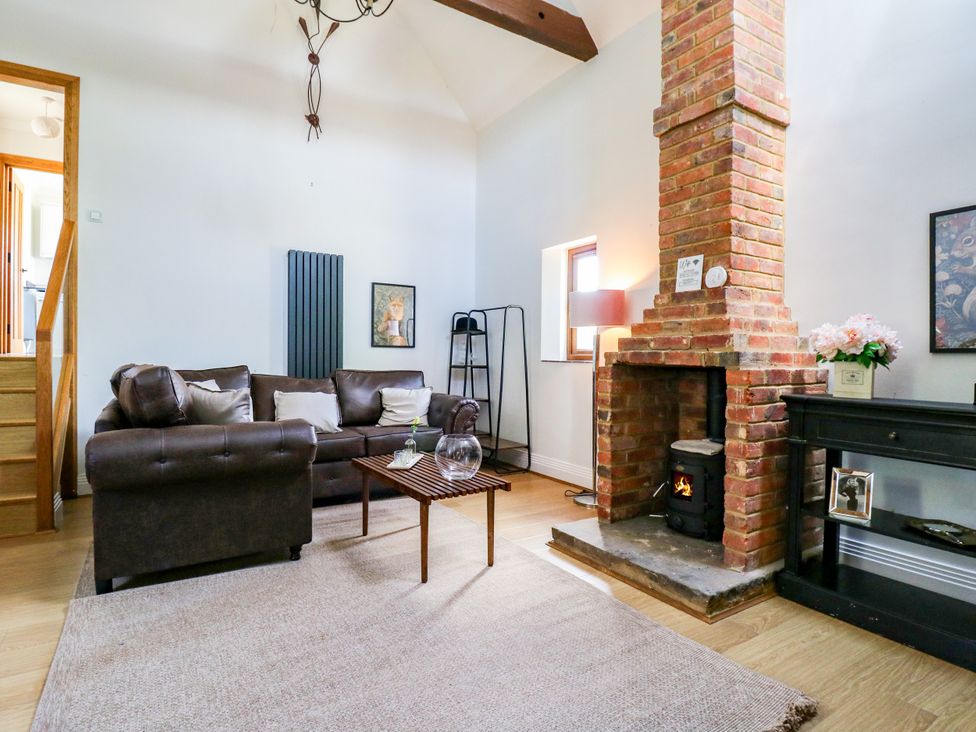 A living room with a sofa and fireplace at Barn Owl Cottage Carlton near Harrold