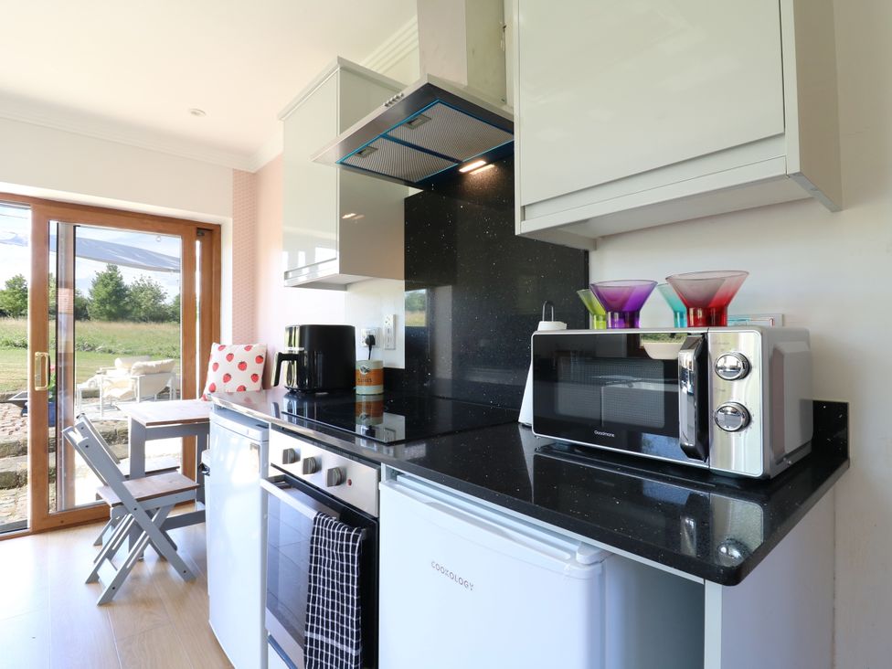 A kitchen with a counter, sink, microwave, and coffee machine at Barn Owl Cottage Carlton near Harrold