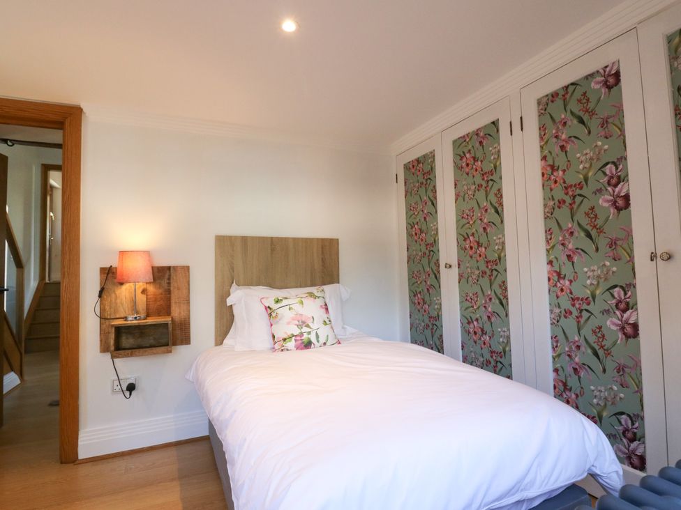 A bedroom with a bed and cupboard at Barn Owl Cottage Carlton near Harrold