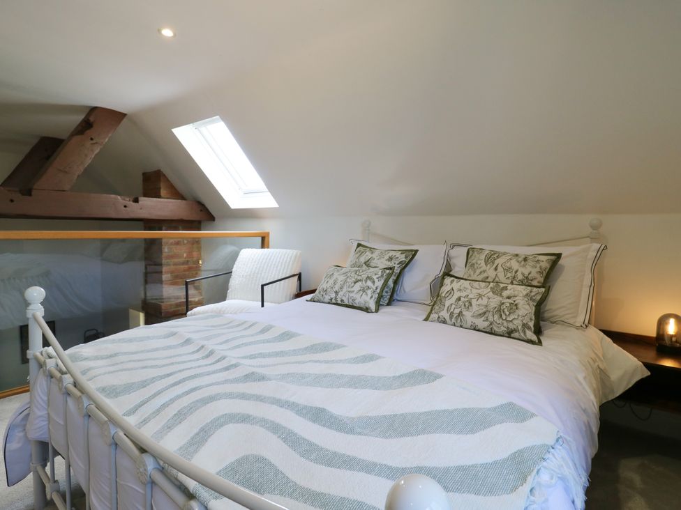 A bedroom with a bed and chair at Barn Owl Cottage in Carlton near Harrold