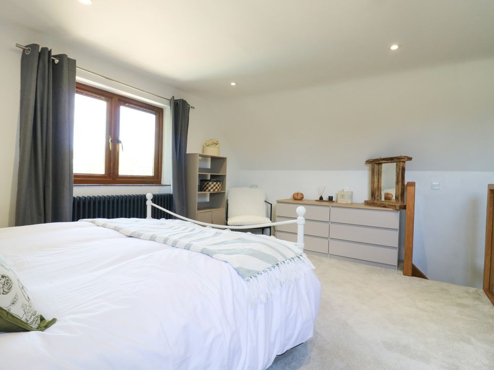 A bedroom with a bed window and shelving unit at Barn Owl Cottage Carlton near Harrold