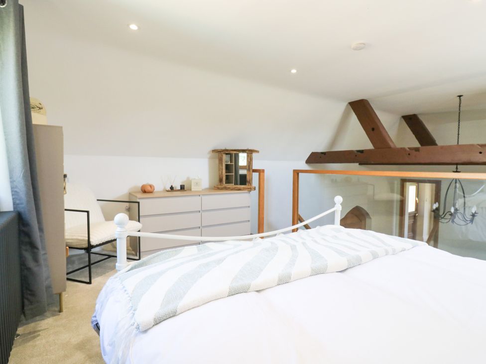 A bedroom with a bed and dresser at Barn Owl Cottage in Carlton near Harrold