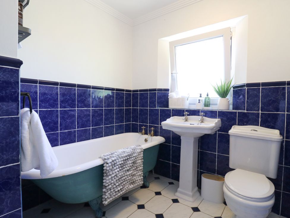 A bathroom with a bathtub and sink at Barn Owl Cottage Carlton near Harrold