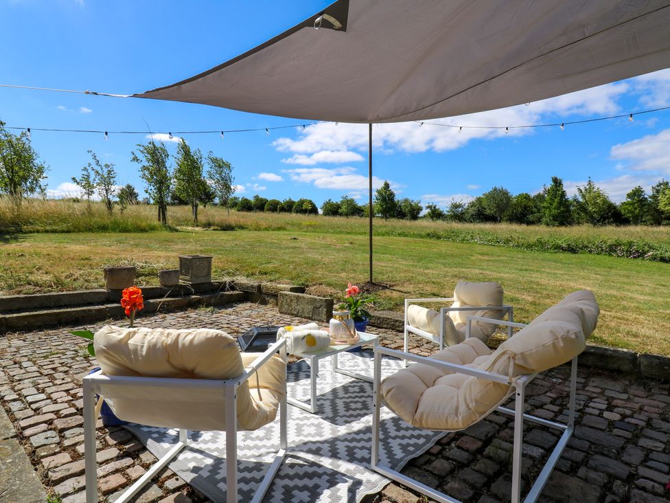 An outdoor seating area with chairs and a table at Barn Owl Cottage Carlton near Harrold