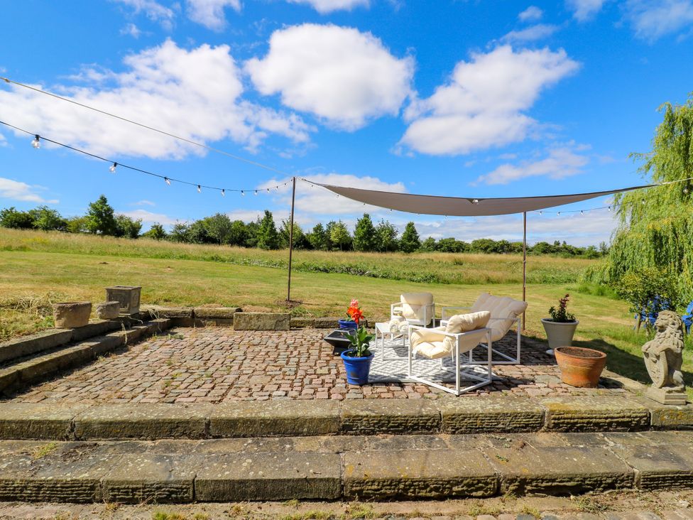 A garden with a cobblestone patio and outdoor seating at Barn Owl Cottage Carlton near Harrold