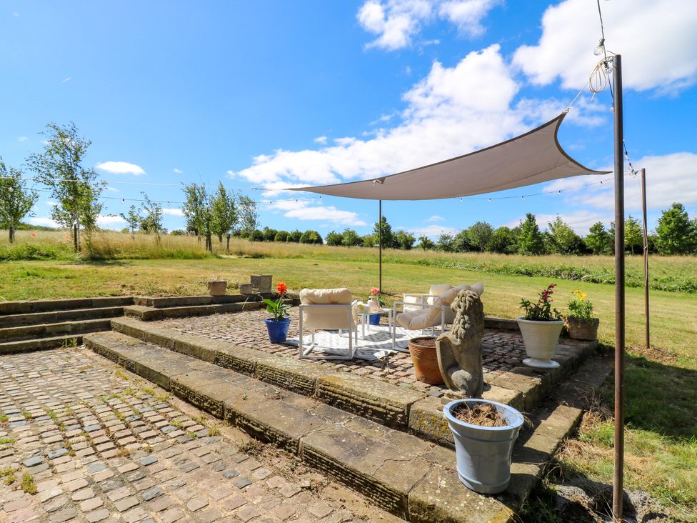 An outdoor sitting area with a table and chairs at Barn Owl Cottage Carlton near Harrold