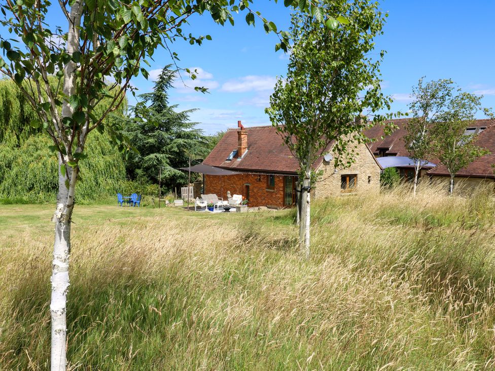 A house with chairs and a table in the garden at Barn Owl Cottage Carlton near Harrold