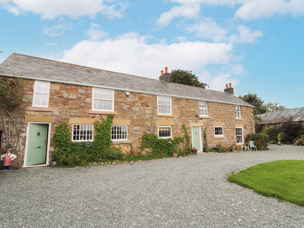 A house with a gravel driveway and garden area at Cae Adar Farm in Wrexham