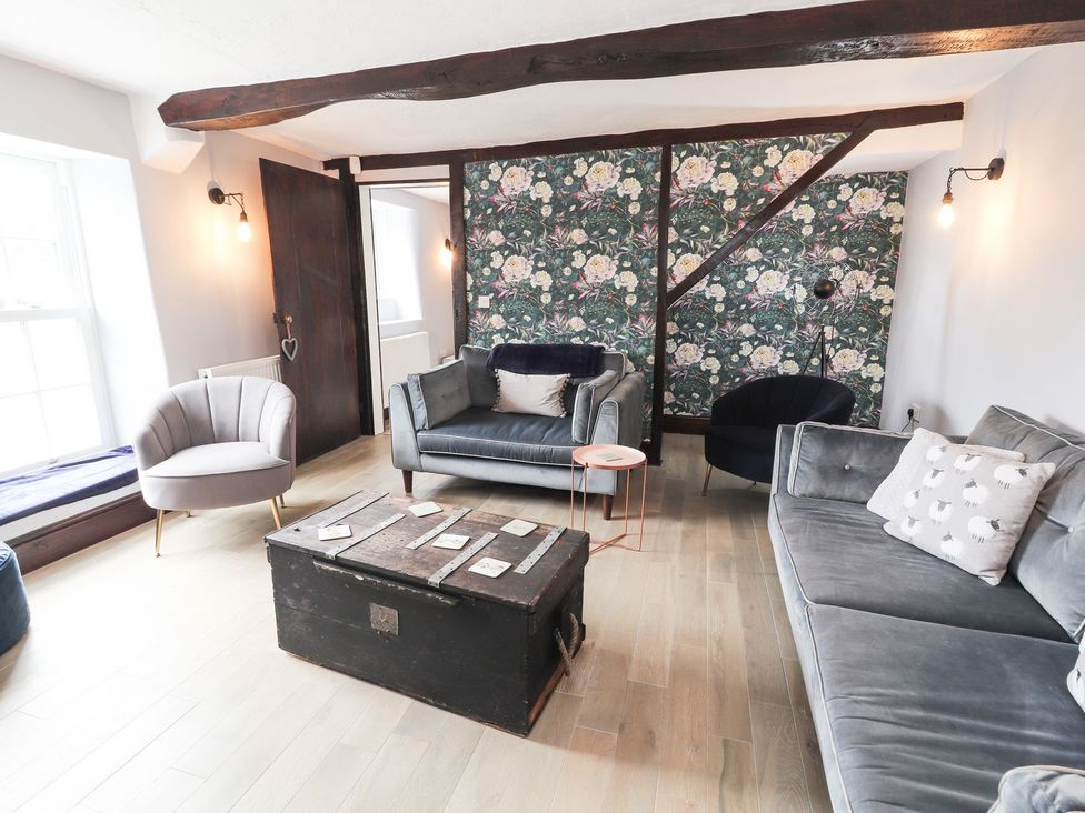 A living room with furniture and a decorative wall at Cae Adar Farm in Wrexham