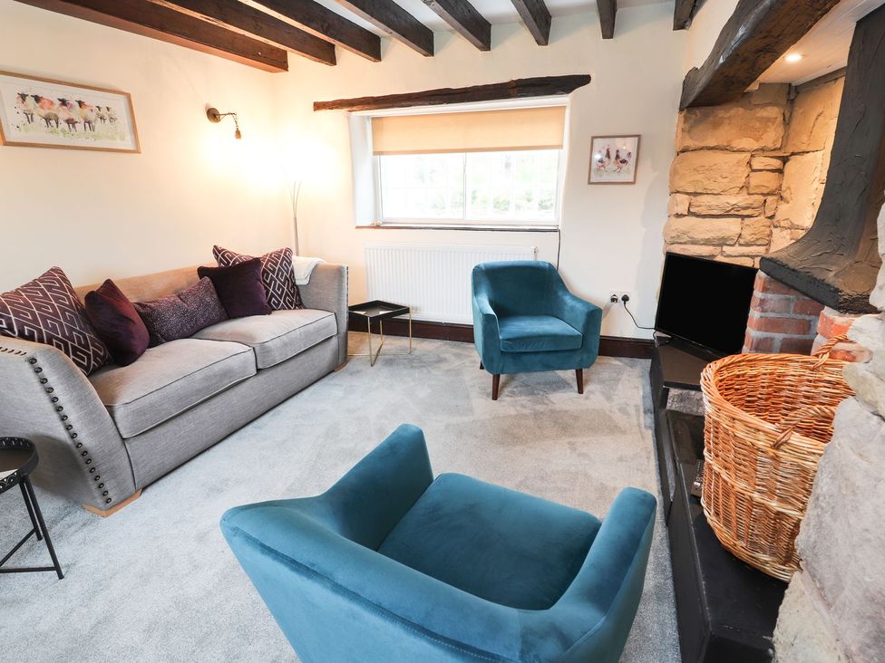 A living room with a sofa and armchair at Cae Adar Farm in Wrexham