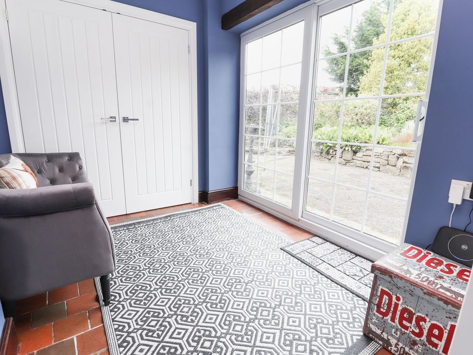 A snug room with a sofa and doors to the garden at Cae Adar Farm in Wrexham