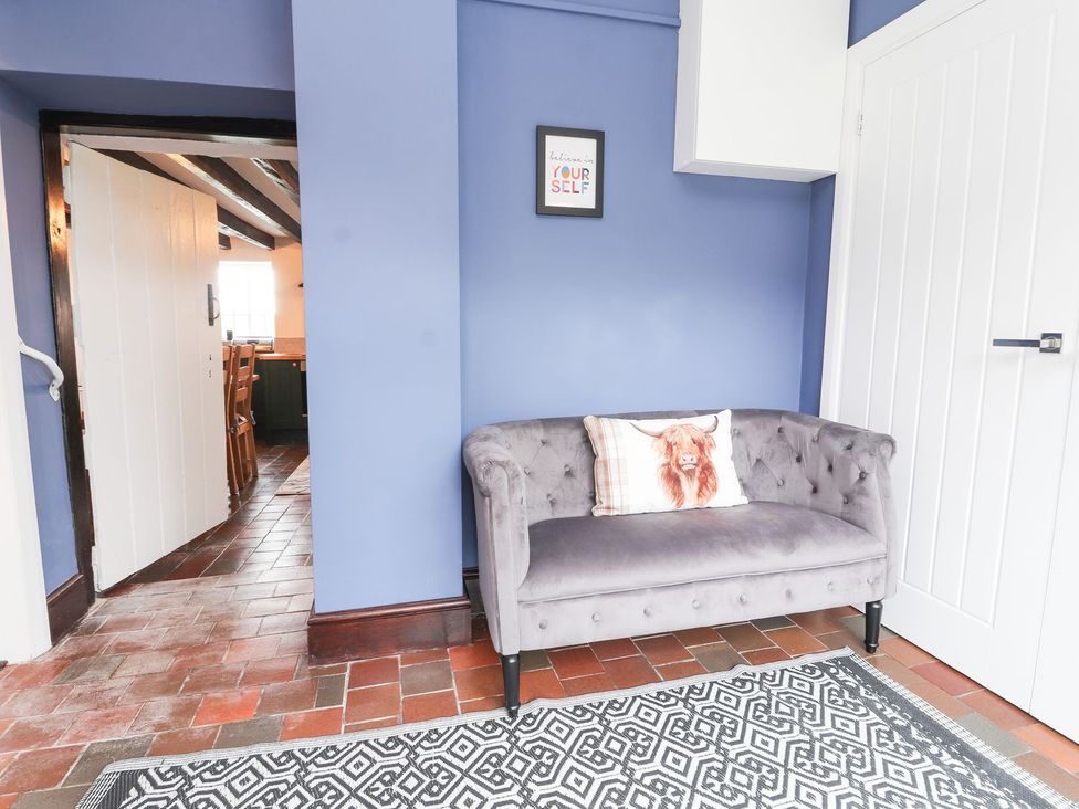 A living room with a sofa and door at Cae Adar Farm in Wrexham