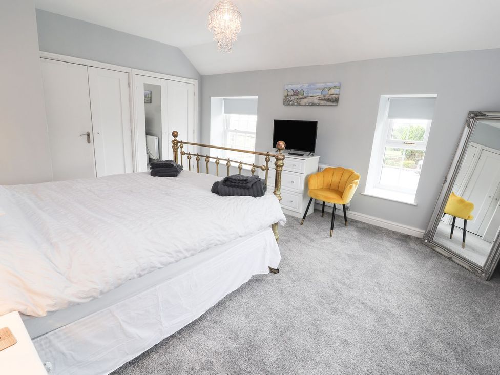 A bedroom with a bed and a television at Cae Adar Farm in Wrexham