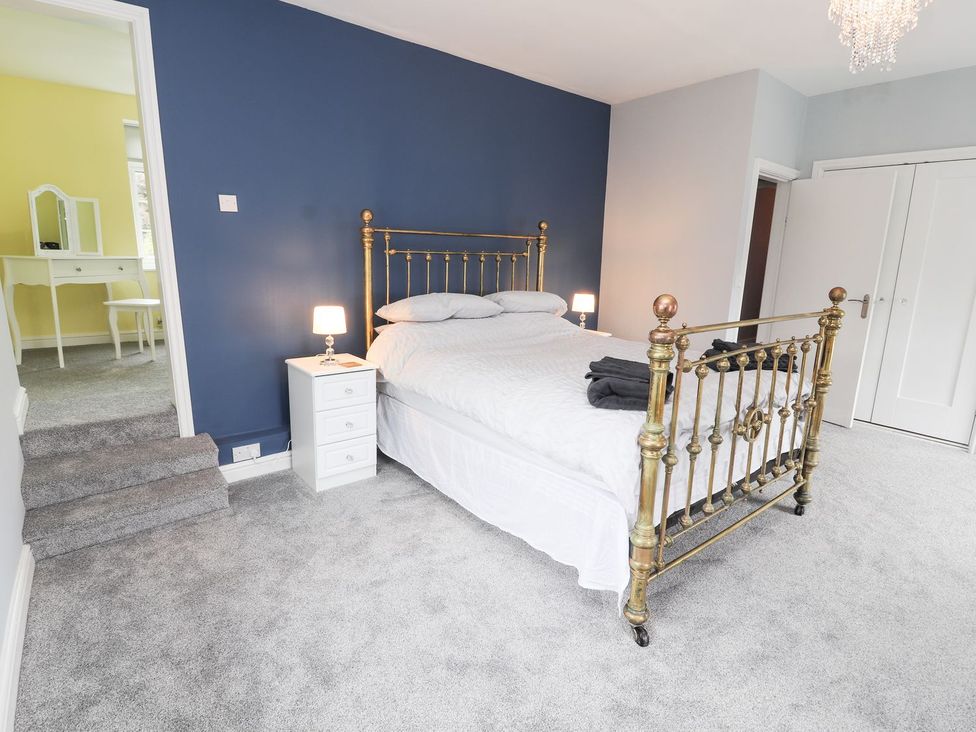 A bedroom with a bed and nightstand at Cae Adar Farm in Wrexham