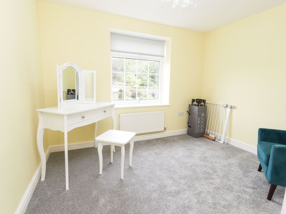 A bedroom with a vanity table and a window at Cae Adar Farm in Wrexham