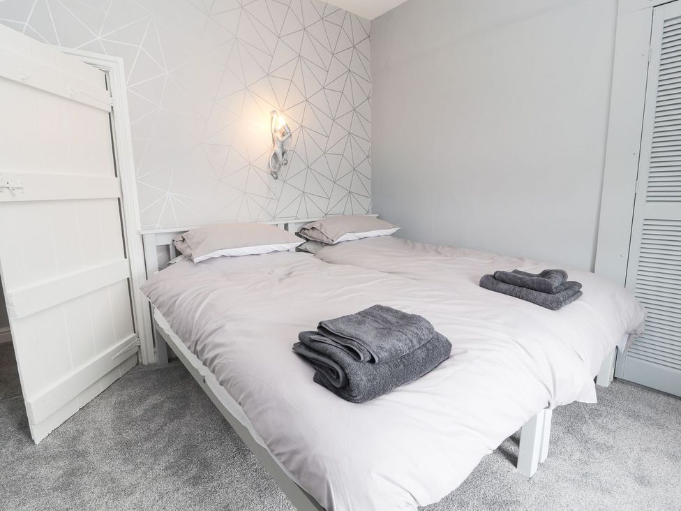 A bedroom with a bed and towels folded at Cae Adar Farm in Wrexham