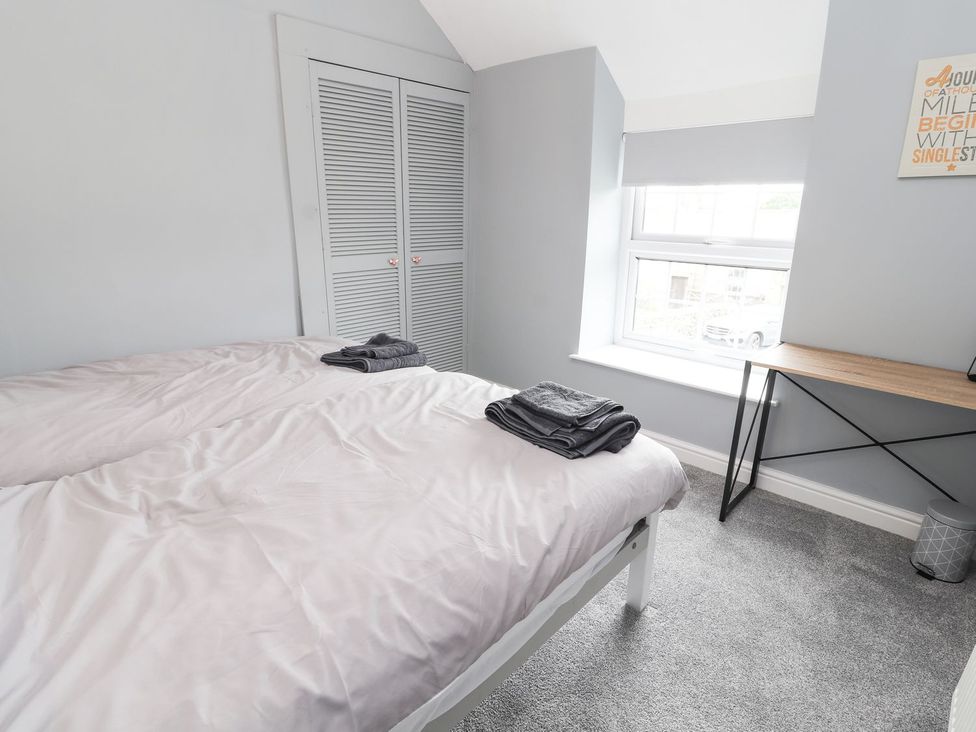 A bedroom with beds and a desk at Cae Adar Farm in Wrexham