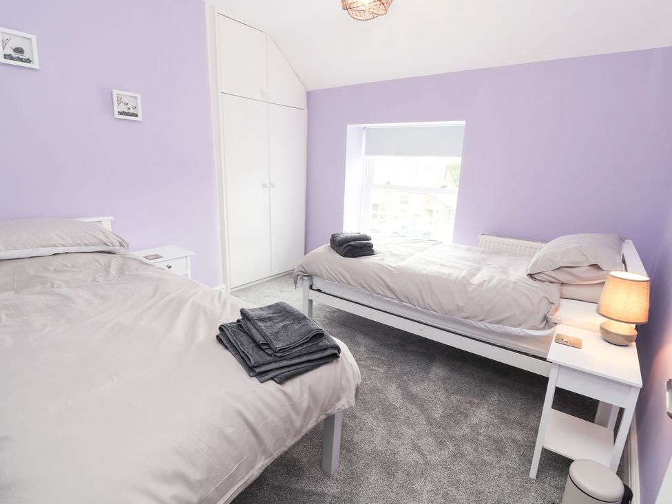 A bedroom with beds and a window at Cae Adar Farm Wrexham