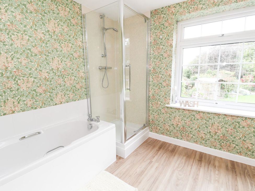 A bathroom with a bath tub and a shower at Cae Adar Farm in Wrexham