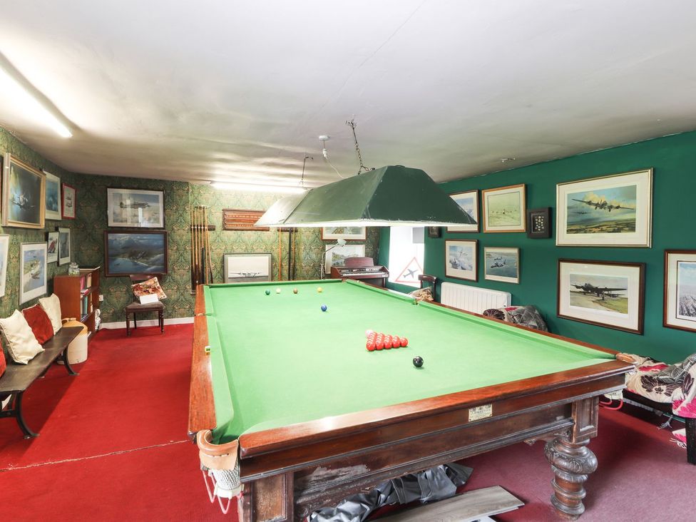 A game room with a billiard table and picture frames at Cae Adar Farm in Wrexham