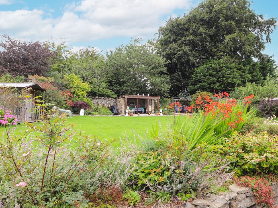 A garden with a shed and outdoor furniture at Cae Adar Farm in Wrexham