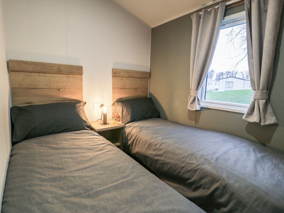 A bedroom with two single beds and a window at Willerby Ellerrton (delyn)