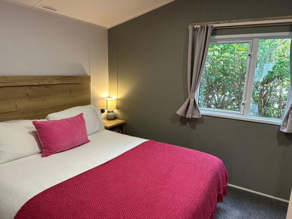 A bedroom with a bed and lamp at Willerby Ellerrton (delyn) Prestatyn