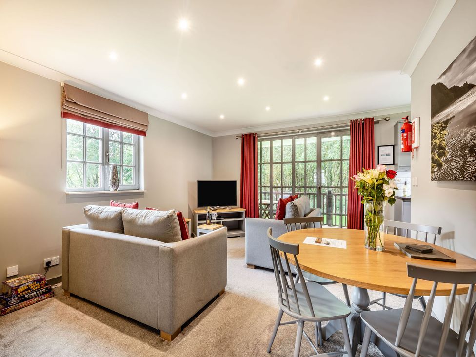 A living room with a sofa and dining area at Arran Lodge Spa Dailly