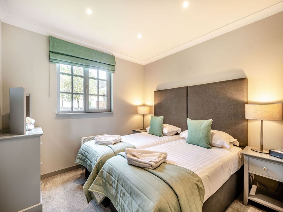 A bedroom with twin beds and bedside tables at Arran Lodge Spa in Dailly