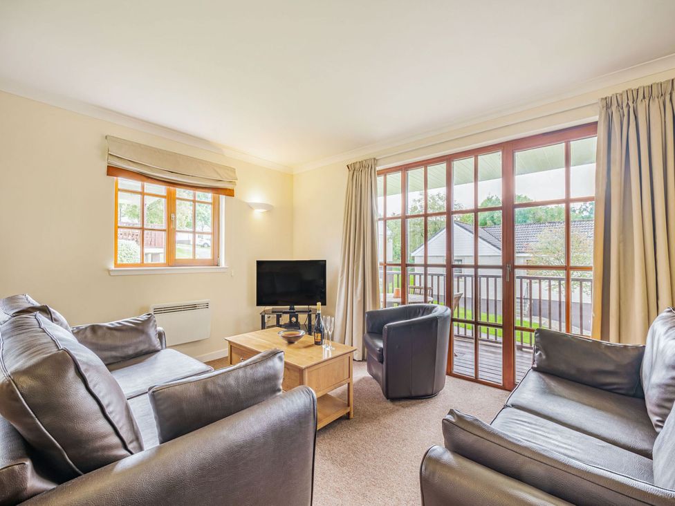 A living room with a television and seating area at Turnberry in Dailly