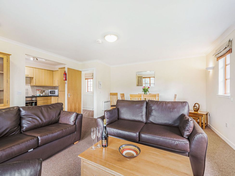 A living room with a sofa and dining area at Turnberry in Dailly