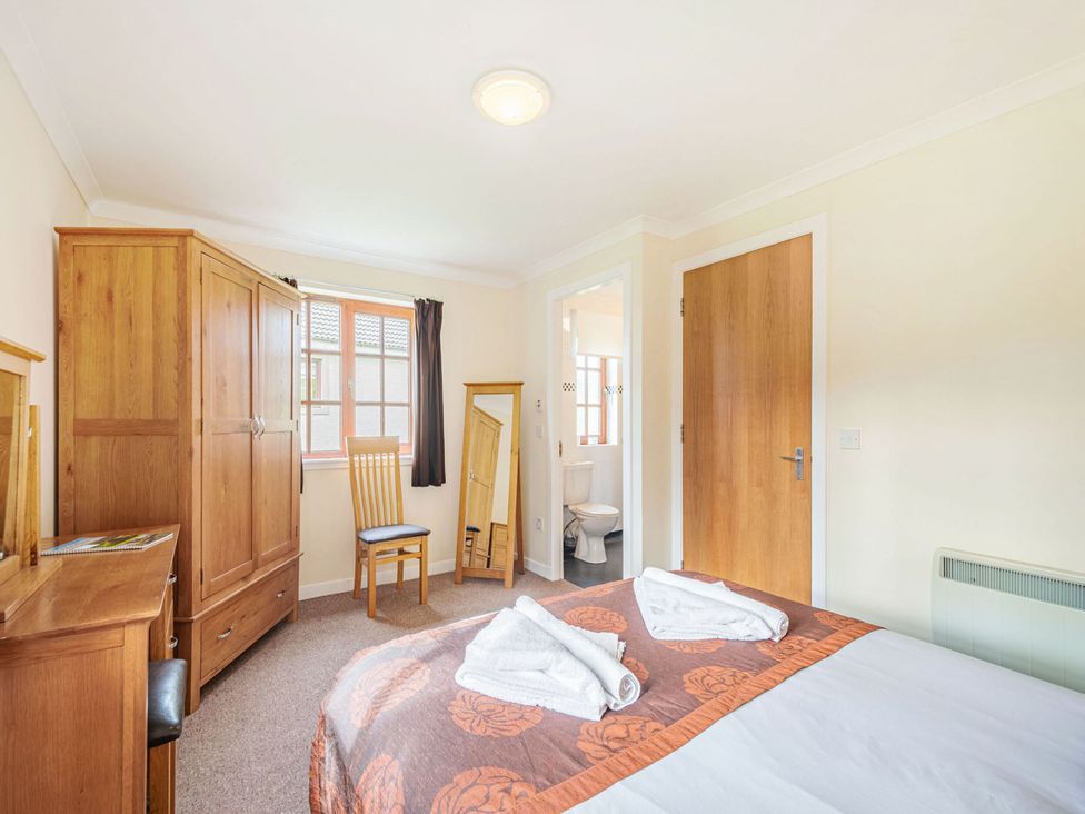 A bedroom with a bed and wardrobe at Turnberry in Dailly