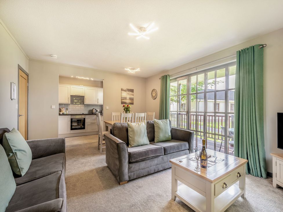 A living room with a sofa and dining area at Brunston in Dailly