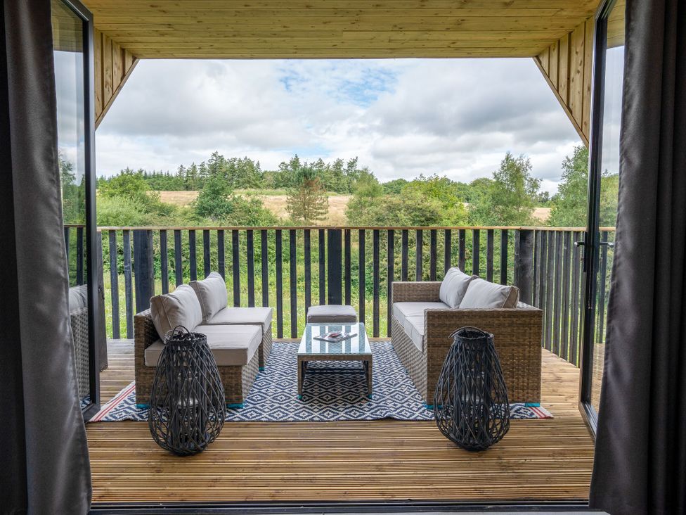 An outdoor lounge area with seating and a table at Orka Duo 2.0 (Pet) in Dumfries